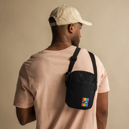 model wearing a crossbody bag featuring a subtle pride flag printed. 