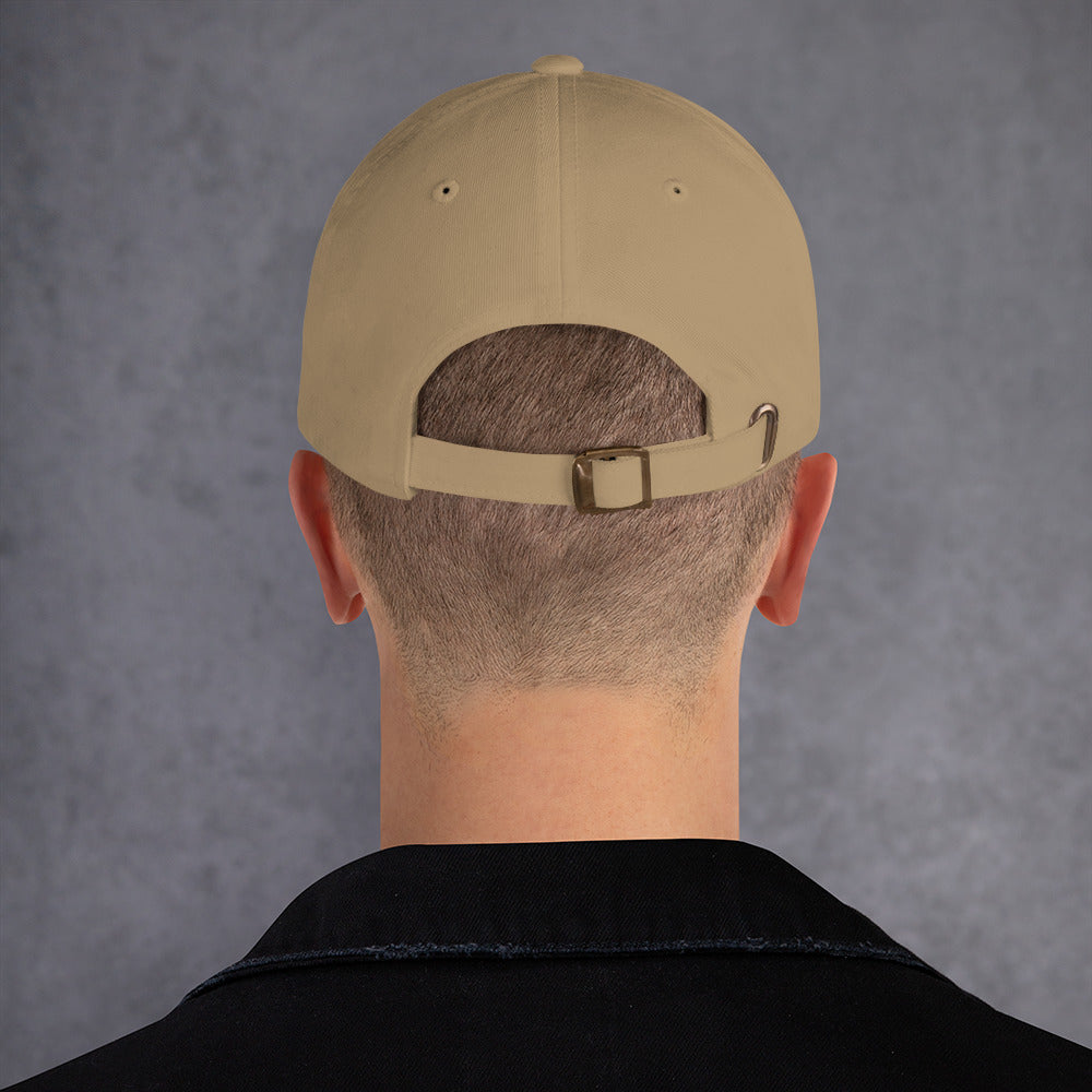 A male model wearing out khaki baseball hat featuring non-binary pride scratch mark embroidery with a low profile, adjustable strap.