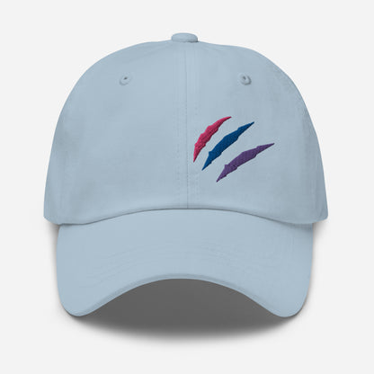 Baseball hat featuring bisexual pride scratch mark embroidery in light blue with a low profile, adjustable strap.