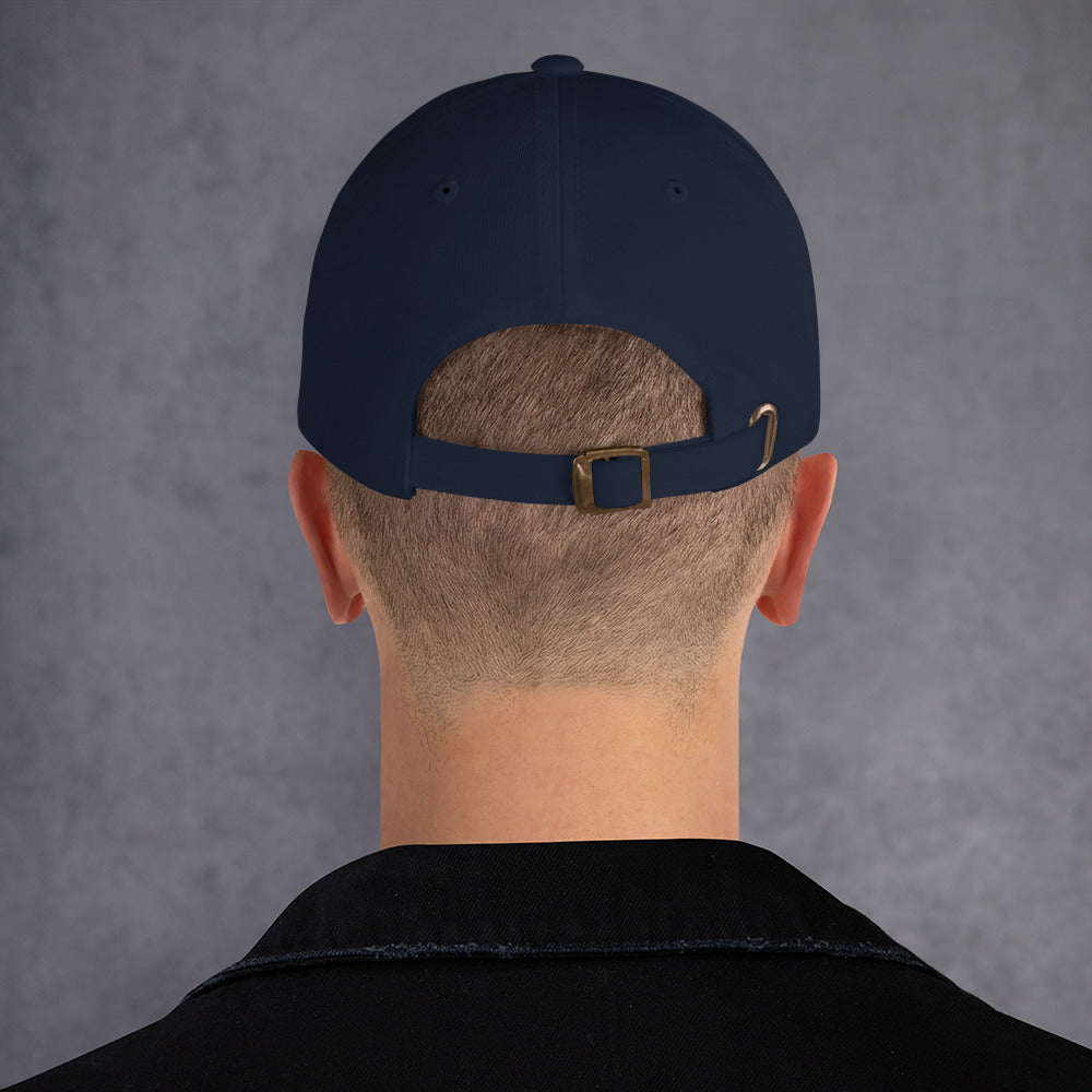 A male model wearing our navy baseball hat featuring rainbow design embroidery with a low profile, adjustable strap.