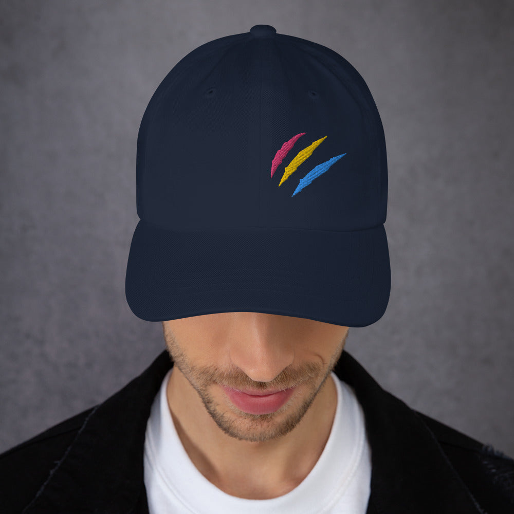 A male model wearing our navy baseball hat featuring pansexual pride scratch mark embroidery with a low profile, adjustable strap.