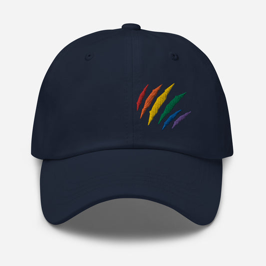 Navy baseball hat featuring rainbow pride scratch mark embroidery with a low profile, adjustable strap.