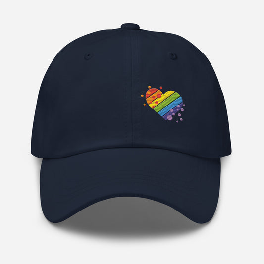 Navy baseball hat featuring rainbow heart design embroidery with a low profile, adjustable strap.