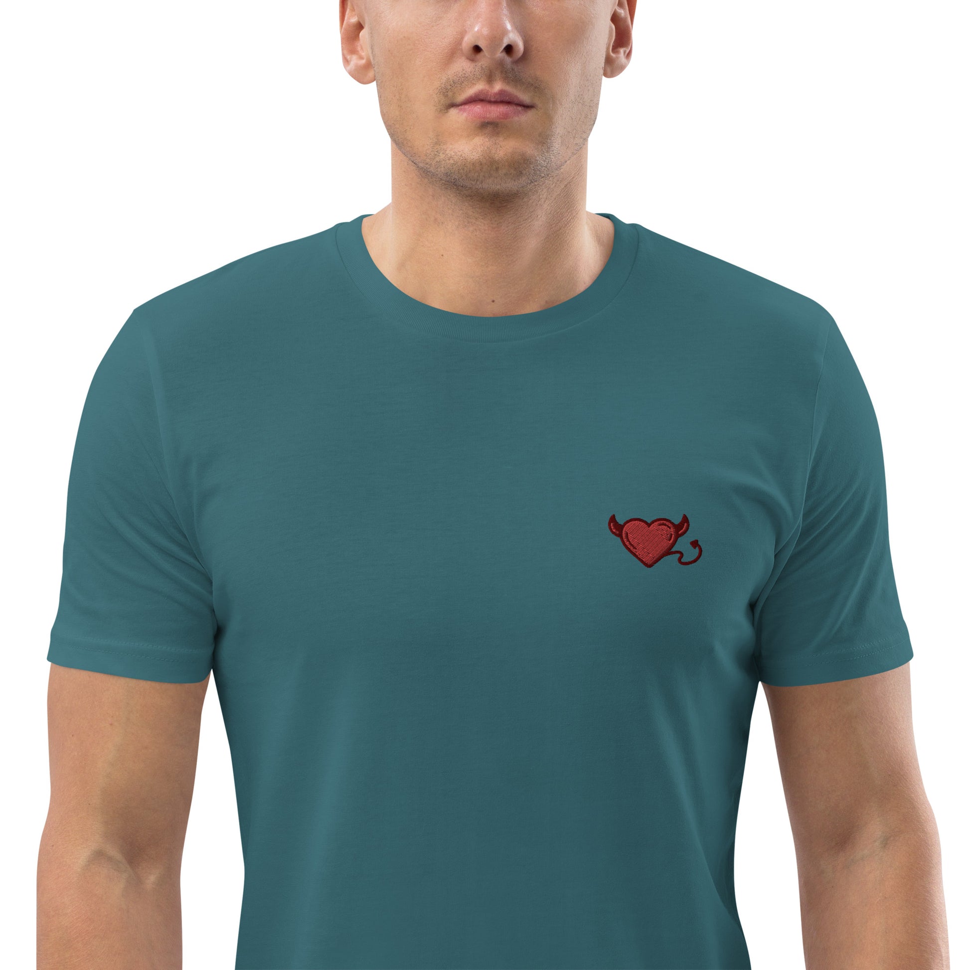 A male model wearing a fitted stargaze blue fitted t-shirt with a red devil's heart embroidered on the left chest. 
