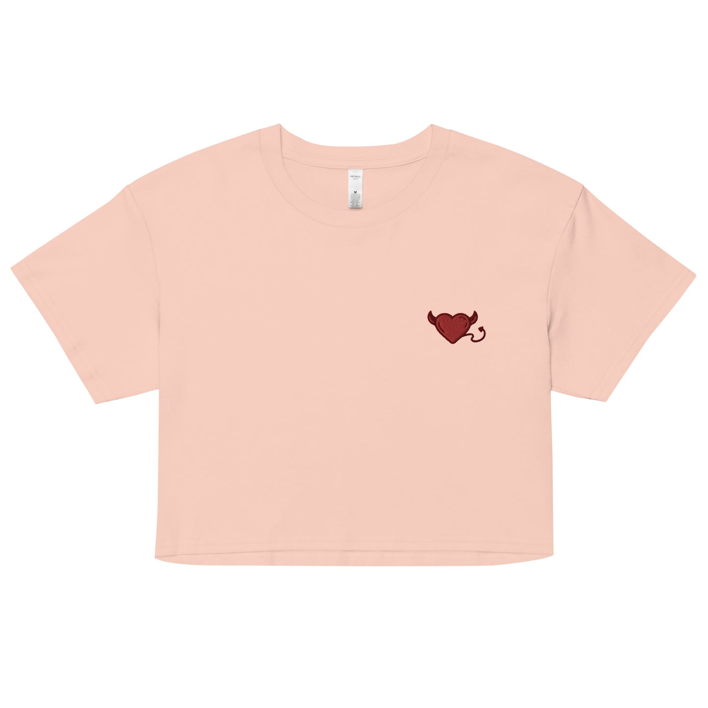 A relaxed, modest pale pink crop top features a subtle red embroidery featuring a devil's heart. Adding a touch of mischief to your look—a playful celebration of lgbtq culture! Made from 100% combed cotton. Available in Extra Small, Small, Medium, Large, Extra Large.