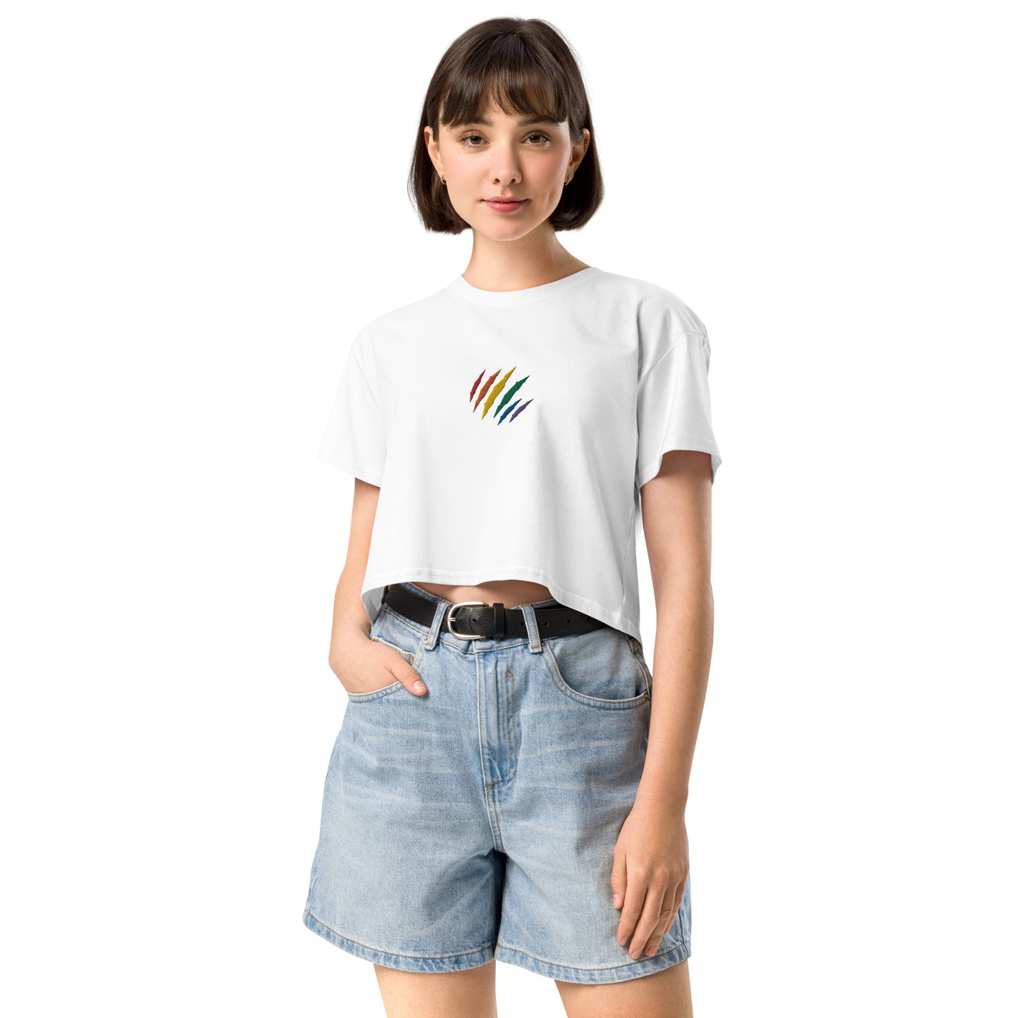 A female model wearing a relaxed, modest white crop top features a subtle rainbow mark embroidery. Adding a touch of rainbow to your look—a playful celebration of lgbtq culture! Made from 100% combed cotton. Available in Extra Small, Small, Medium, Large, Extra Large.