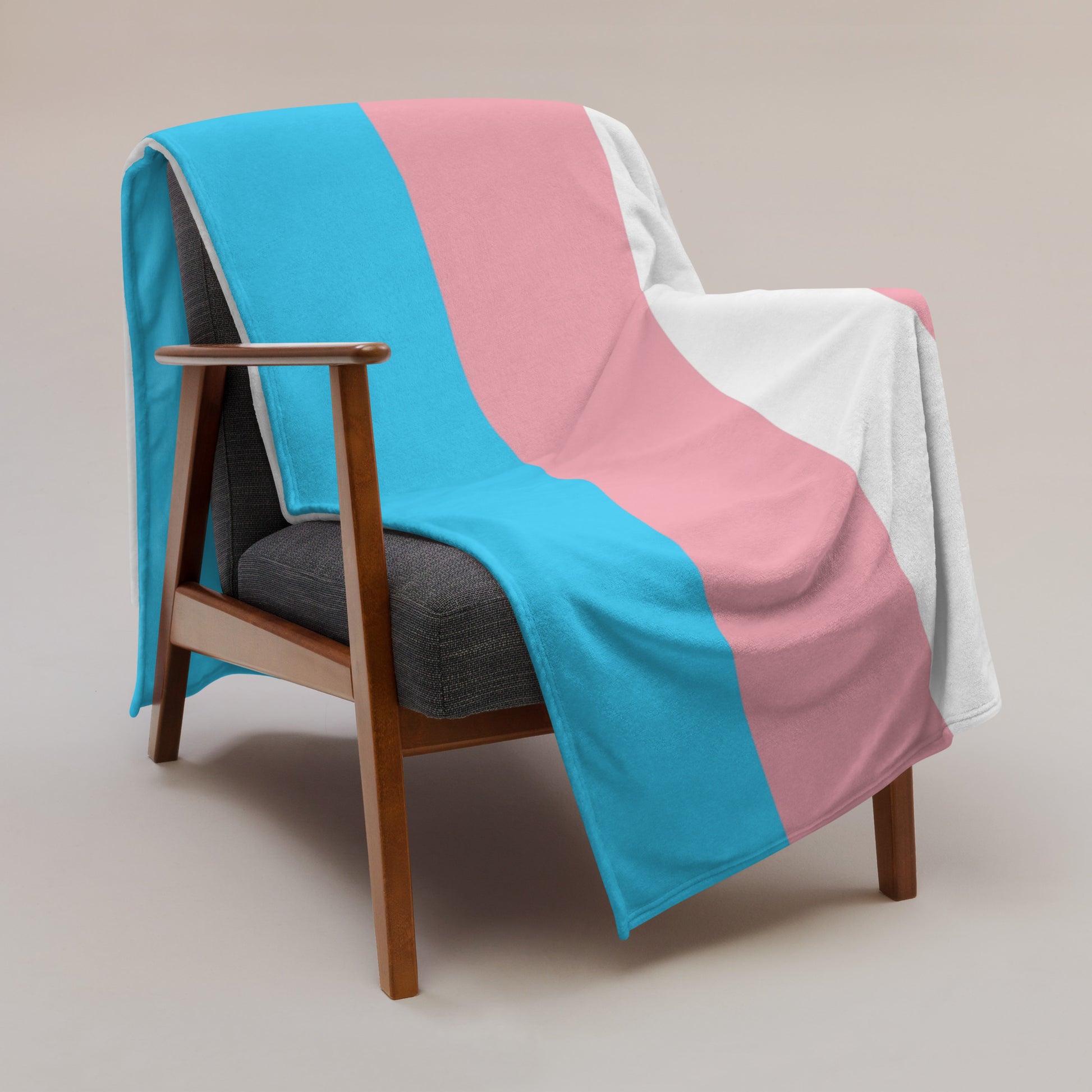 Soft throw blanket hanging over an arm chair. Transgender pride flag colors with beautiful stained glass affect print