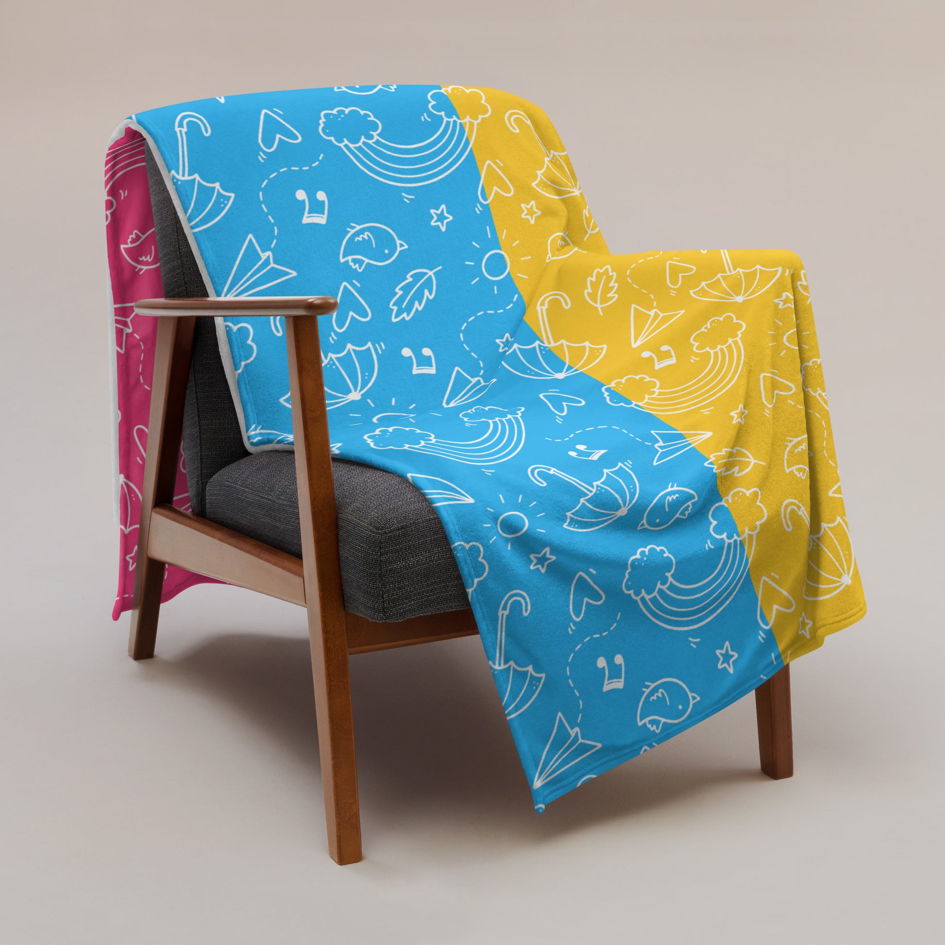 Soft throw blanket hanging over an armchair. Pansexual pride flag colors with cute lgbtq doodle print