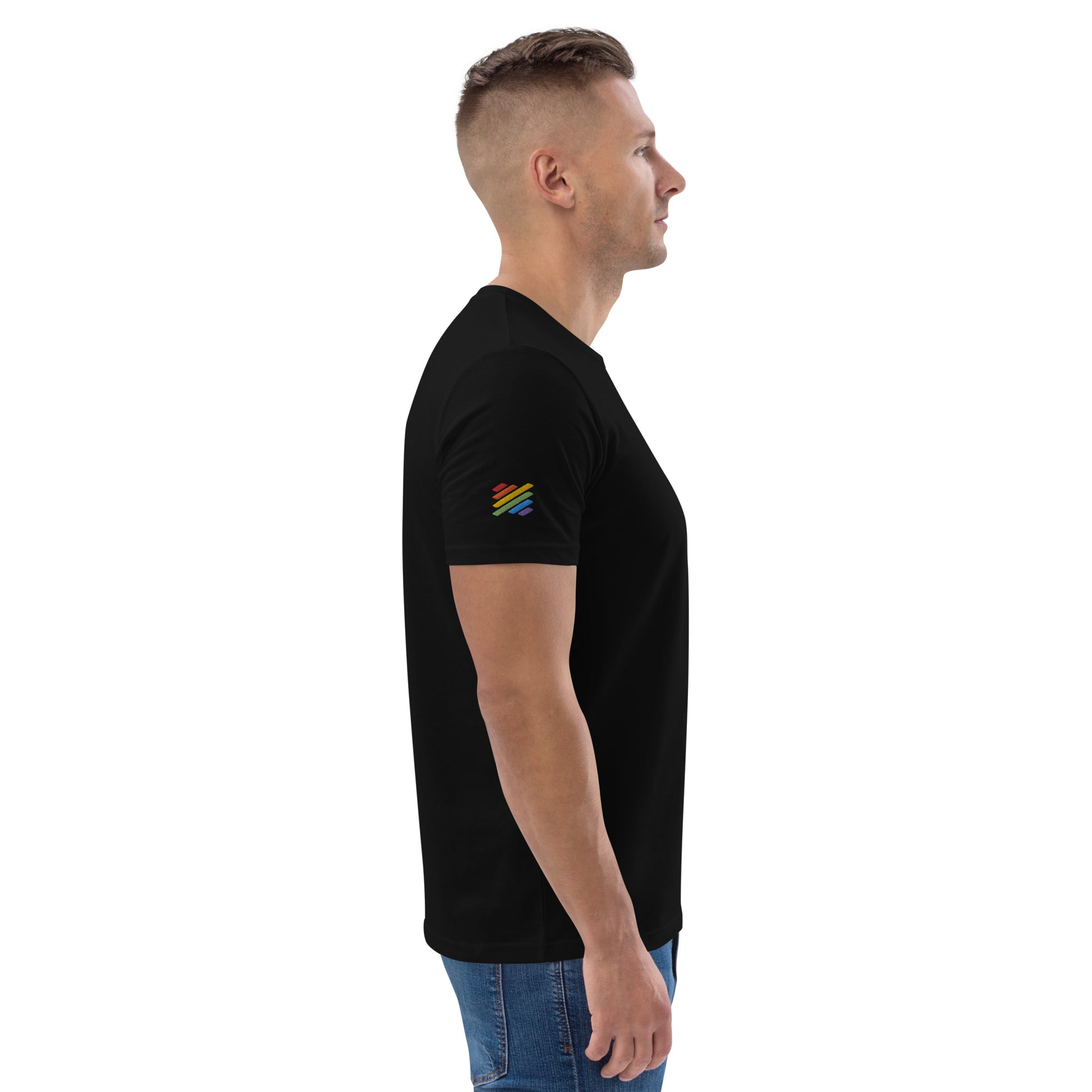 Male model wearing a fitted black organic cotton t-shirt with a small embroidered line art of two men kissing on the left chest. Available in sizes S to 3XL.